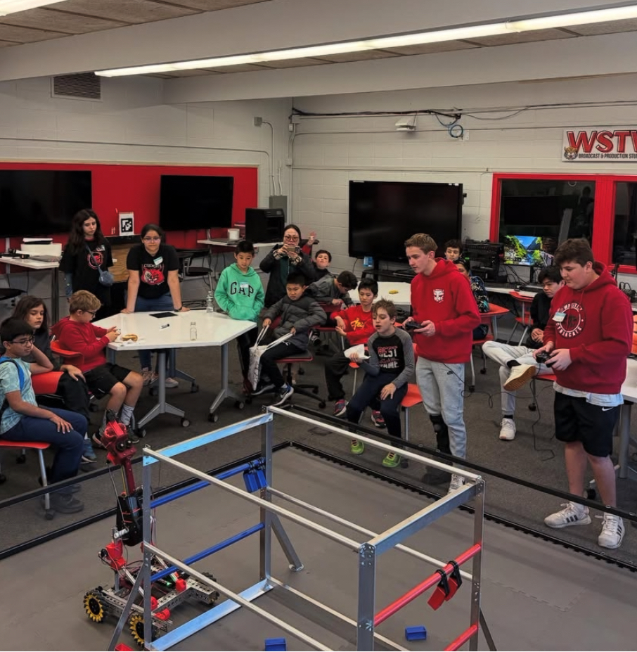 Students learning from CyberCats robot demonstration during educational visit