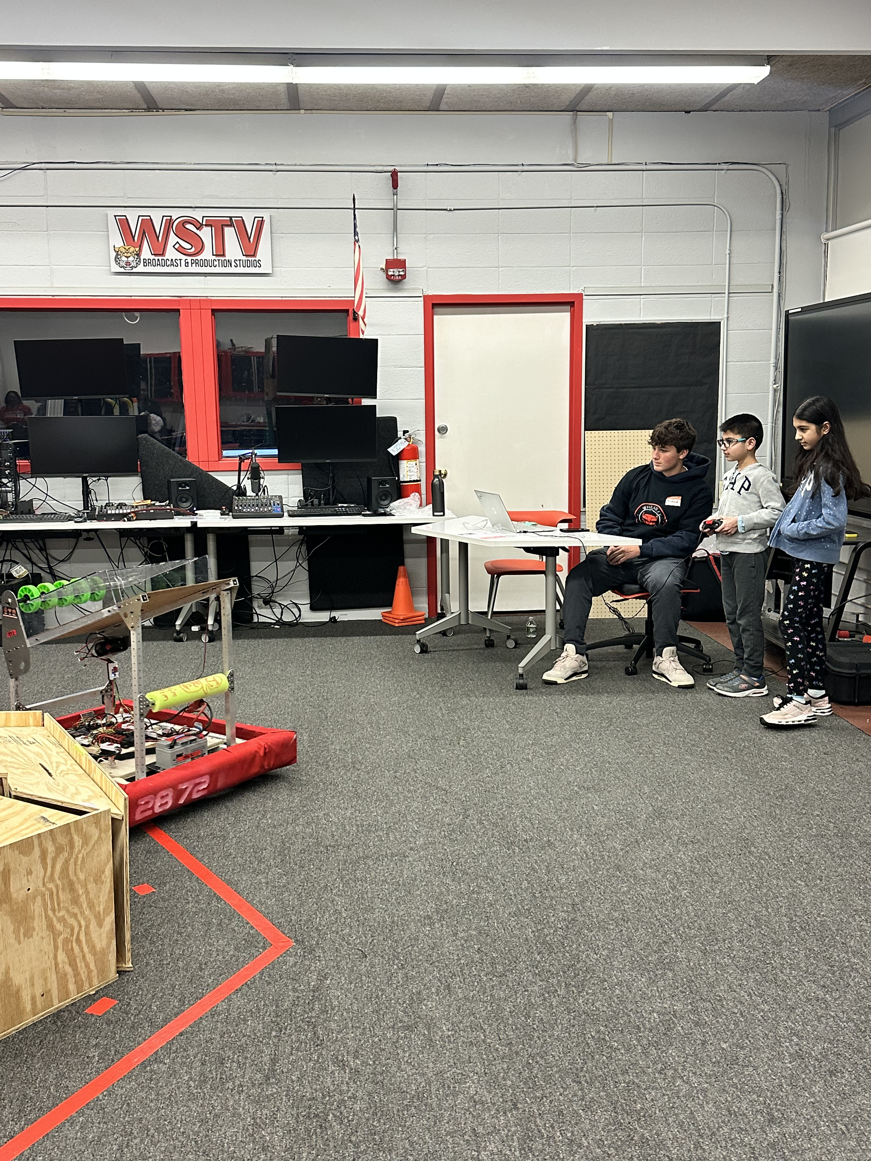 CyberCats robot demonstration at STEAM fair with students watching