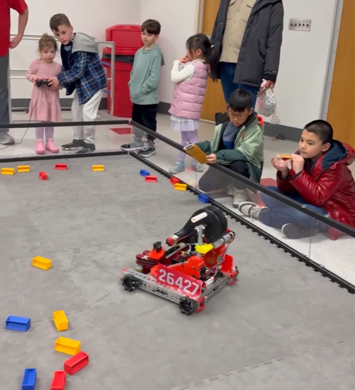 Young students watching FTC robot demonstration with CyberCats team